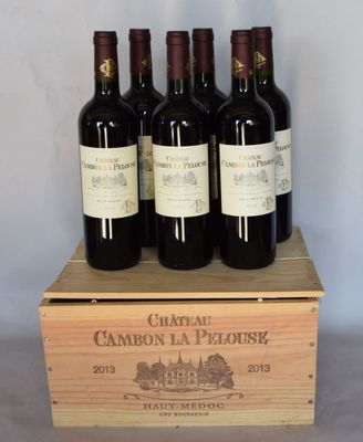 quatre bouteilles de vin dans un coffret en bois posé sur une table