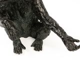 statue of a black monkey sitting on a white surface