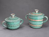 pair of green and white teapots and covers