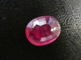 a close up of a red ruby stone on a black surface