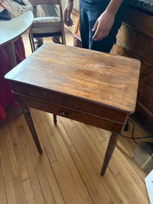 une personne debout à côté d'une table sur laquelle se trouve un couteau