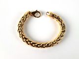 a close up of a gold bracelet on a white surface