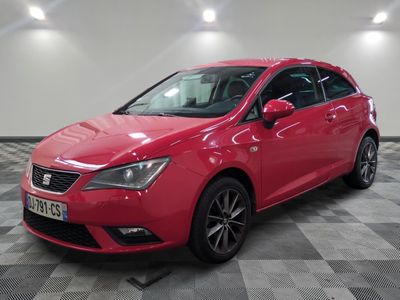une voiture rouge est garée sur le sol en damier d'un garage