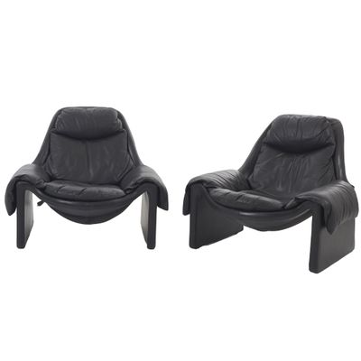 une paire de fauteuils de salon en cuir noir aux pieds courbés