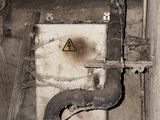 a picture of a dirty bathroom with a toilet and pipes