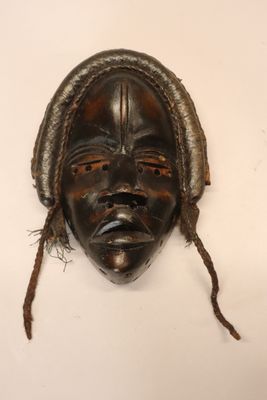 un vieux masque en bois avec des dreadlocks sur fond blanc