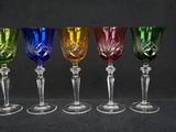 six different colored wine glasses are lined up in a row