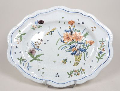 une assiette décorée de fleurs, posée sur un socle