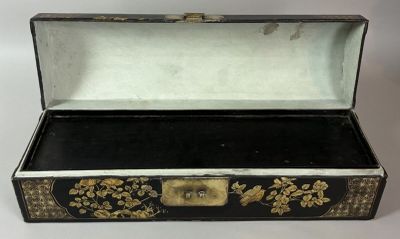 an old black and gold box with gold flowers on it