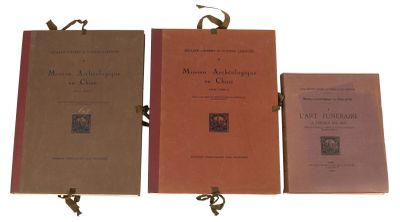 trois livres sont alignés sur une surface blanche