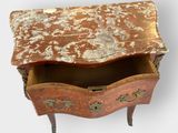 a small chest of drawers with a marble top