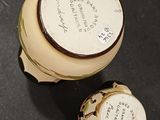 a small jar with a lid that has a picture on it