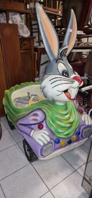 une petite voiture avec un lapin dessus, dans une pièce