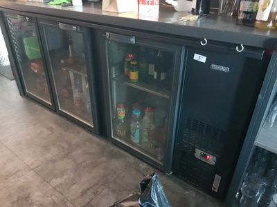 a black refrigerator sitting next to a counter in a kitchen