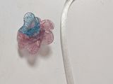 a small plastic flower with a ribbon attached to it