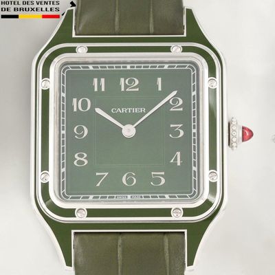une montre verte exposée sur une surface blanche