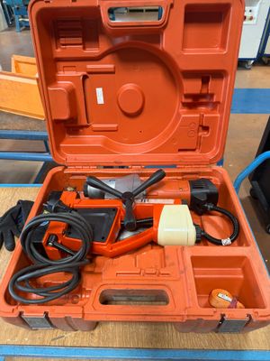 une boîte à outils orange contenant des outils, posée sur une table