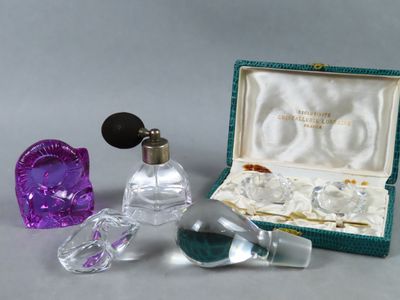 two small glass perfume bottles in a green case and a purple glass heart shaped bottle