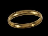 gros plan d'une bague en or sur fond noir