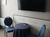 two chairs and a table in a room with a flat screen tv on the wall