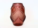 a red glass vase with a design on it