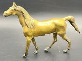 statue of a golden horse on a gray surface
