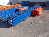 plusieurs piles de palettes bleues et orange dans la cour d'un entrepôt
