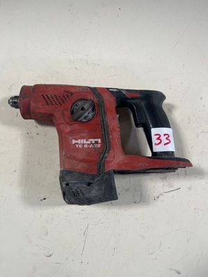 une image représentant une perceuse à fil rouge posée sur une surface blanche