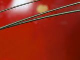 a close up of a red table with a metal wire on top of it