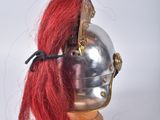 a silver helmet with red hair on a wooden stand
