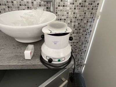 a blender sitting on a counter next to a bowl of water