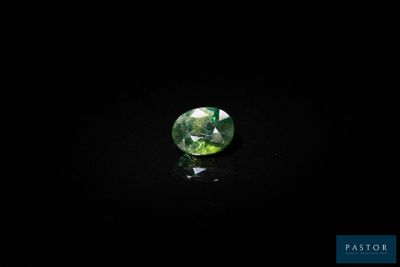 a green tourmaline gems on a black surface