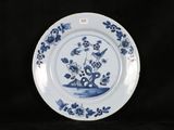 a blue and white plate with flowers and birds on it