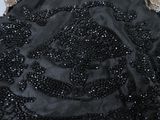 a close up of a black dress with sequins on it