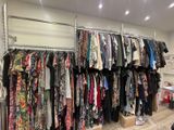 a rack of clothes in a clothing store with clothes hanging on it