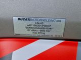 the back end of a red motorcycle with a sticker on it