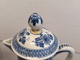 a blue and white teapot with a lid on a table