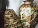 two vases sitting on a table next to a lamp