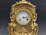 a gold clock that is sitting on top of a table