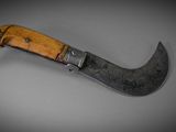 a close up of a knife with a wooden handle on a table