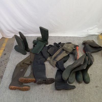 de nombreuses paires de bottes alignées par terre