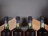 three bottles of wine sit in a wooden box on a table