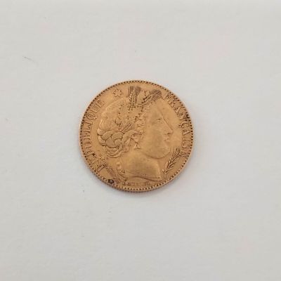 gros plan d'une pièce d'or sur une surface blanche