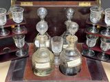 many glasses and bottles on a table with a wooden tray