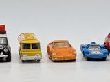 several toy cars are lined up in a row on a white surface