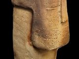 statue of a man ' s head made of clay on a black background