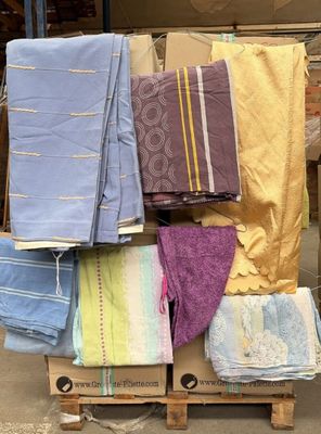 une pile de serviettes posée sur une palette devant un immeuble