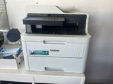 a white printer sitting on top of a white desk