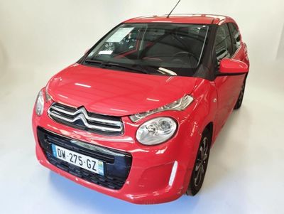 une voiture rouge garée dans une pièce blanche