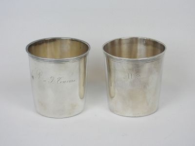 une paire de tasses en métal argenté sur lesquelles sont gravés des noms